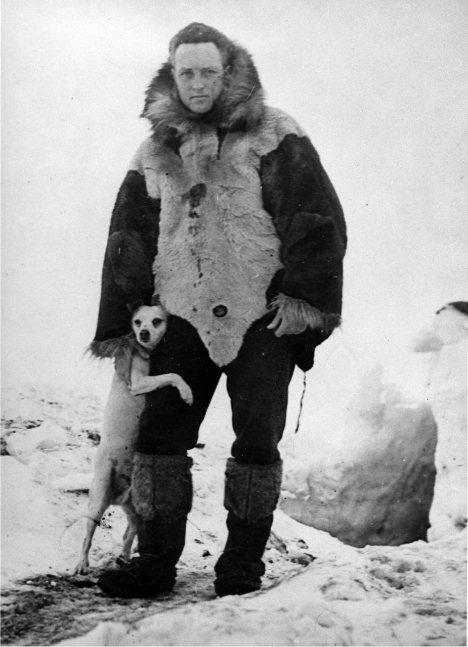 Dressed in furs, with his dog "Igloo", outside a hut during his first Antarctic Expedition, 12 April 1930. Official U.S. Navy Photograph, National Archives collection